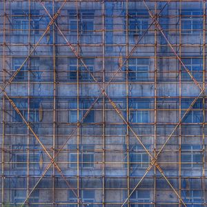 Full frame shot of metal fence against blue wall