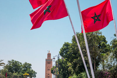 Low angle view of flag amidst buildings against sky