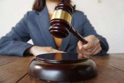 Close-up of a person holding tea cup on table