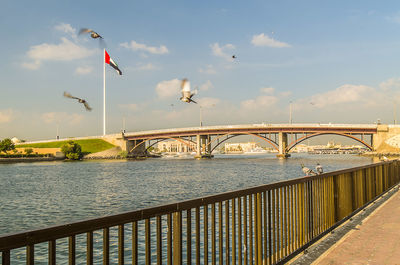 Bridge over river in city against sky