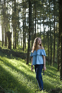 Full length of woman walking in forest