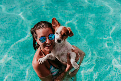 Young man with dog in swimming pool