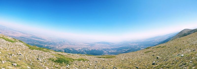 Scenic view of mountains against blue sky