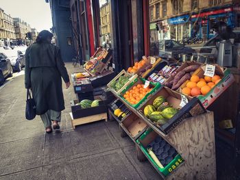 Pedestrian walking past fruit shop