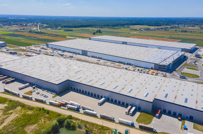 Aerial shot of industrial warehouse loading dock where many truck with semi trailers load