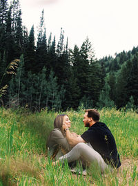 Young couple on land against trees