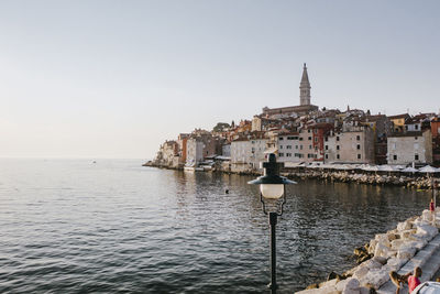 View of buildings by sea against clear sky