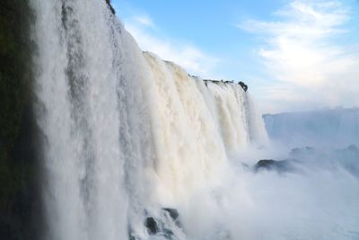 Scenic view of waterfall against sky