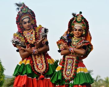 Low angle view of woman standing against multi colored sky