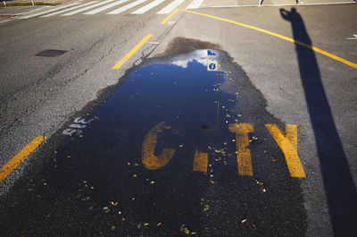 High angle view of puddle on road with city text