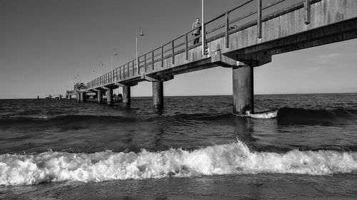 Bridge over sea against clear sky