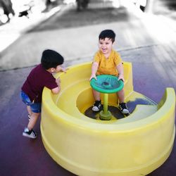 Boy playing with yellow sitting outdoors