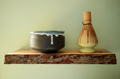 Close-up of bowl on table against wall
