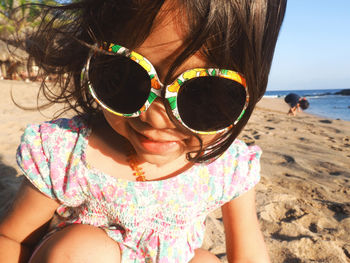 Close-up of girl wearing sunglasses at beach