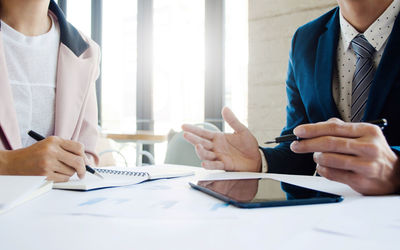 Midsection of couple holding hands on table