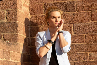 Portrait of a young woman against wall