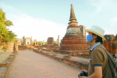 Visitor wearing face mask during a visit to wat phra si sanphet amid covid-19, ayutthaya, thailand