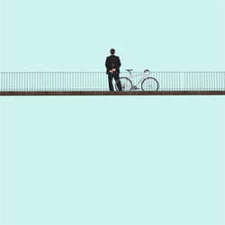 Man with bicycle on railing in city