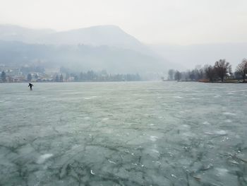 Frozen lake against sky during winter