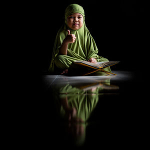 Portrait of a smiling young woman reading book