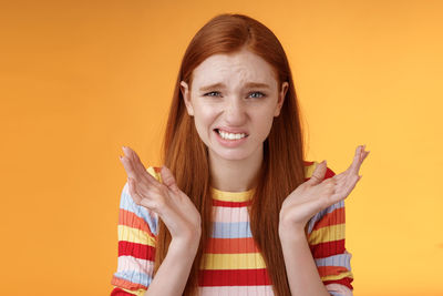 Displeased woman against yellow background