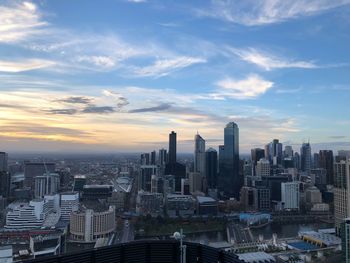 Modern buildings in city against sky during sunset