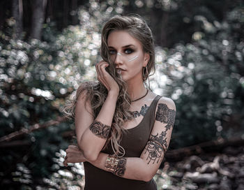 Portrait of woman standing against tree