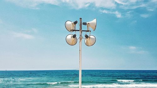 Street light on beach against sky