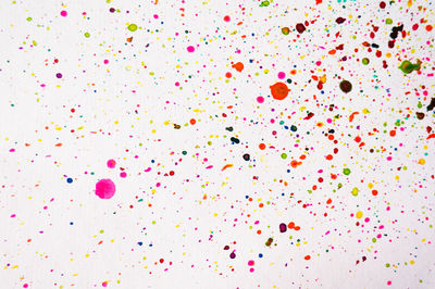 Full frame shot of colorful paint stains over white background