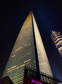 Low angle view of illuminated buildings against sky at night