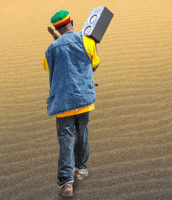 Rear view of boy standing with umbrella