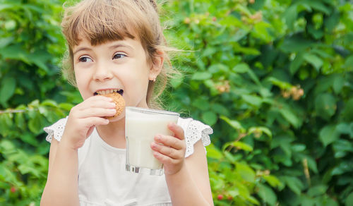 Portrait of young woman drinking milk in park