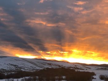 Scenic view of snowcapped mountains against sky during sunset