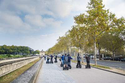 Group of people by the road against sky