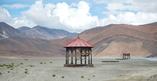 Scenic view of tower and mountains against sky