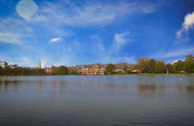 Scenic view of lake by buildings against sky