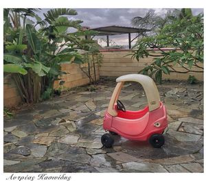 Red car in yard against building