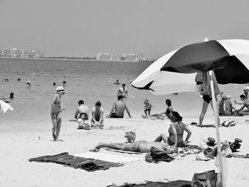 People on beach against clear sky