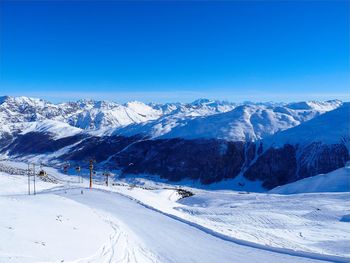Scenic view of snowcapped mountains against clear blue sky