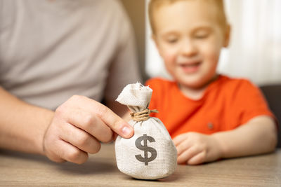 Dad and son are holding a dollar money bag. family savings and budget. money saving for child
