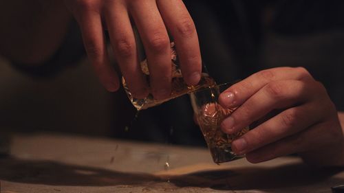 Midsection of man mixing drinks on table