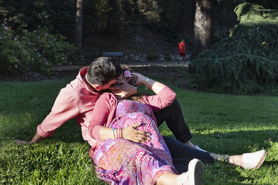 Rear view of couple sitting at park