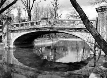 Arch bridge over river against sky