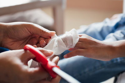 Parent helping her child perform first aid finger injury after she has been an accident.