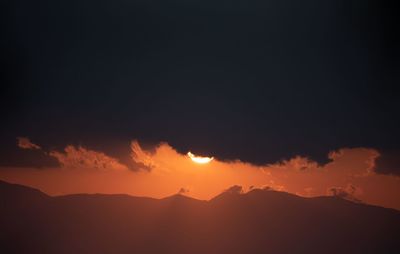 Scenic view of silhouette mountains against romantic sky at sunset