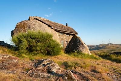 Old building on mountain against clear blue sky