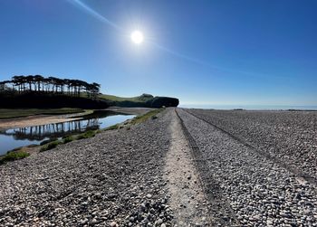 Surface level of road against blue sky on sunny day