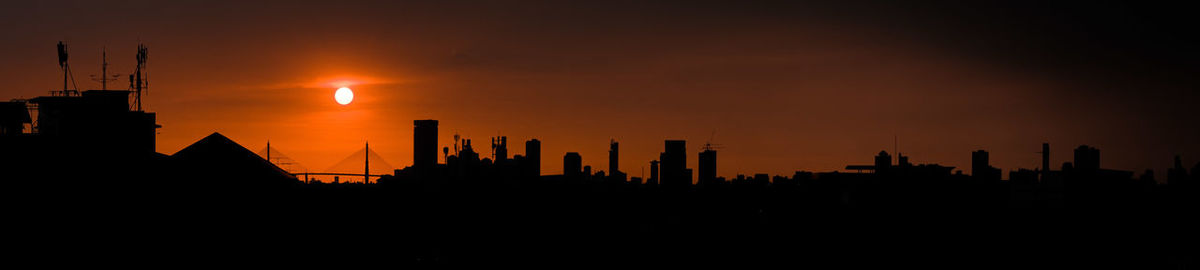 Silhouette buildings against sky during sunset