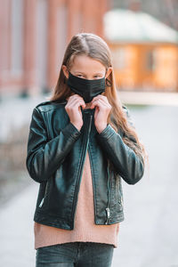 Girl wearing mask while standing outdoors