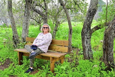 Young woman sitting on bench in park